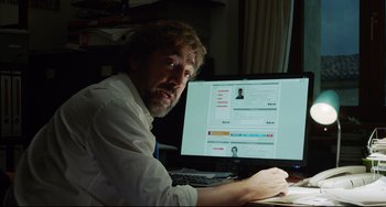 Movie still from “Everybody Knows” (2018), directed by Asghar Farhadi – A man sitting in front of a computer screen; Close Up shot, Over the shoulder angle