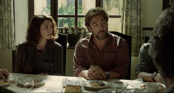 Movie still from “Everybody Knows” (2018), directed by Asghar Farhadi – A man and a woman sitting at a dinner table; Medium shot, Over the shoulder angle