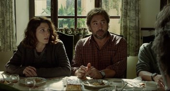 Movie still from “Everybody Knows” (2018), directed by Asghar Farhadi – A man and a woman sitting at a dinner table; Medium shot, Over the shoulder angle
