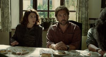 Movie still from “Everybody Knows” (2018), directed by Asghar Farhadi – A man and a woman sitting at a dinner table; Medium shot, Over the shoulder angle