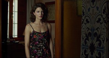 Movie still from “Everybody Knows” (2018), directed by Asghar Farhadi – A woman in a floral dress standing next to a door; Medium shot, Over the shoulder angle
