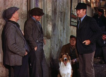 Movie still from “Lassie Come Home” (1943), directed by Fred M. Wilcox – A group of men standing next to each other with a dog; Medium shot, Low angle