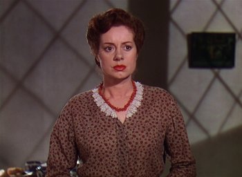 Movie still from “Lassie Come Home” (1943), directed by Fred M. Wilcox – An older woman wearing a brown and white dress; Close Up shot, Over the shoulder angle