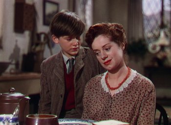 Movie still from “Lassie Come Home” (1943), directed by Fred M. Wilcox – A boy and a woman sitting at a dinner table; Medium shot, Low angle