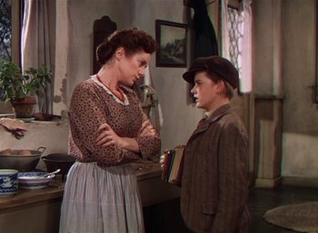 Movie still from “Lassie Come Home” (1943), directed by Fred M. Wilcox – An older woman and a young boy in a room; Medium shot, Over the shoulder angle