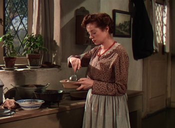 Movie still from “Lassie Come Home” (1943), directed by Fred M. Wilcox – A woman in a brown and white polka dot shirt stirring a bowl; Medium shot, High angle