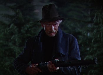 Movie still from “Lassie Come Home” (1943), directed by Fred M. Wilcox – An old man holding a rifle in a dark forest; Close Up shot, Low angle