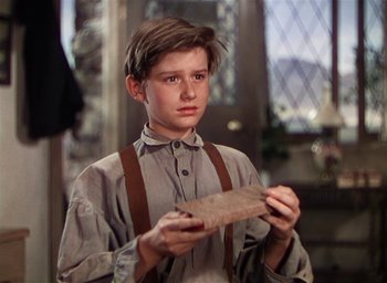 Movie still from “Lassie Come Home” (1943), directed by Fred M. Wilcox – A young boy holding a piece of paper in his hands; Close Up shot, High angle
