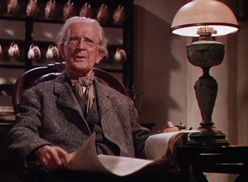 Movie still from “Lassie Come Home” (1943), directed by Fred M. Wilcox – An older man sitting in a chair reading a newspaper; Medium shot, Low angle