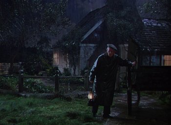 Movie still from “Lassie Come Home” (1943), directed by Fred M. Wilcox – An old man holding a lantern in the rain; Wide shot, High angle