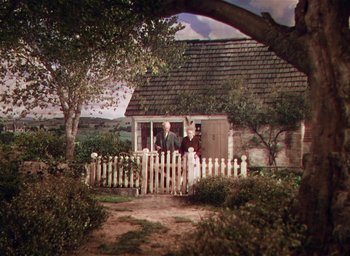 Movie still from “Lassie Come Home” (1943), directed by Fred M. Wilcox – Two men and a dog standing in front of a house; Extreme Wide shot, High angle