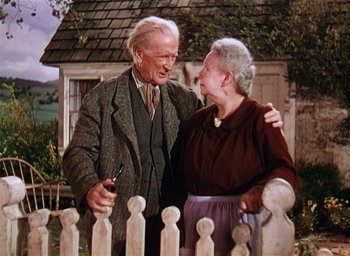 Movie still from “Lassie Come Home” (1943), directed by Fred M. Wilcox – An older man standing next to an older woman in front of a fence; Medium shot, Low angle
