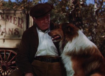 Movie still from “Lassie Come Home” (1943), directed by Fred M. Wilcox – A man and a dog standing next to each other; Medium shot, Low angle
