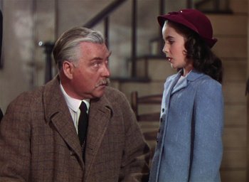 Movie still from “Lassie Come Home” (1943), directed by Fred M. Wilcox – An older man and a young girl are talking to each other; Medium shot, Over the shoulder angle