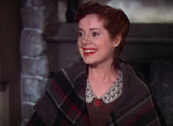 Movie still from “Lassie Come Home” (1943), directed by Fred M. Wilcox – A woman with red hair wearing a sweater and smiling; Close Up shot, High angle