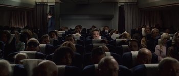 Movie still from “Last Chance Harvey” (2008), directed by Joel Hopkins – A group of people sitting in a row of seats on an airplane; Wide shot, High angle