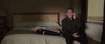 Movie still from “Last Chance Harvey” (2008), directed by Joel Hopkins – A man sitting on a bed talking on a phone; Medium shot, High angle