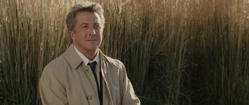 Movie still from “Last Chance Harvey” (2008), directed by Joel Hopkins – A man in a trench coat standing in front of tall grass; Close Up shot, Over the shoulder angle