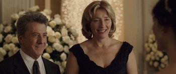 Movie still from “Last Chance Harvey” (2008), directed by Joel Hopkins – A woman in a black dress smiling for the camera; Close Up shot, Over the shoulder angle
