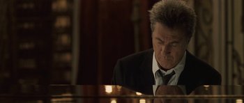 Movie still from “Last Chance Harvey” (2008), directed by Joel Hopkins – An older man wearing a suit and tie is sitting at a piano; Close Up shot, Low angle