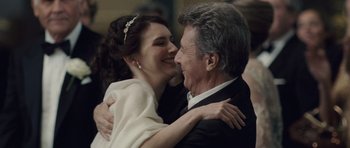 Movie still from “Last Chance Harvey” (2008), directed by Joel Hopkins – A man and a woman hugging each other in front of a crowd; Close Up shot, Over the shoulder angle