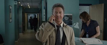 Movie still from “Last Chance Harvey” (2008), directed by Joel Hopkins – A man in a trench coat talking on a cell phone; Close Up shot, Over the shoulder angle