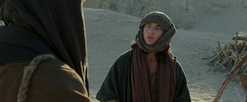 Movie still from “Last Days in the Desert” (2015), directed by Rodrigo García – A man in a robe and a scarf is standing in the desert; Close Up shot, Over the shoulder angle