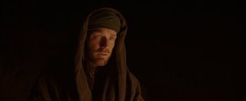 Movie still from “Last Days in the Desert” (2015), directed by Rodrigo García – A man wearing a brown robe and a black head covering; Close Up shot, Low angle