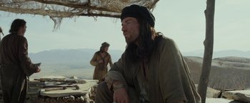 Movie still from “Last Days in the Desert” (2015), directed by Rodrigo García – A man with long hair sitting on the ground next to another man; Medium shot, Low angle