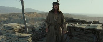 Movie still from “Last Days in the Desert” (2015), directed by Rodrigo García – A man dressed as jesus standing in a field; Medium shot, Low angle