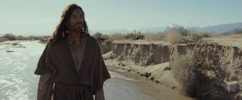 Movie still from “Last Days in the Desert” (2015), directed by Rodrigo García – A man standing in the desert near a river; Medium shot, Low angle
