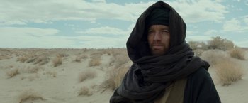 Movie still from “Last Days in the Desert” (2015), directed by Rodrigo García – A man with a beard wearing a black scarf; Close Up shot, Over the shoulder angle