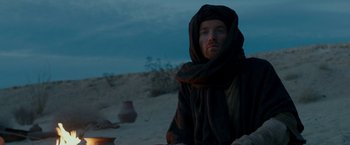 Movie still from “Last Days in the Desert” (2015), directed by Rodrigo García – A man with a beard wearing a black robe; Medium shot, Over the shoulder angle