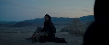 Movie still from “Last Days in the Desert” (2015), directed by Rodrigo García – A man sitting on the ground in the desert at night; Wide shot, Low angle
