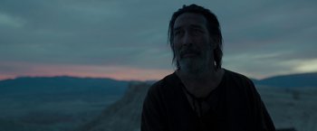 Movie still from “Last Days in the Desert” (2015), directed by Rodrigo García – A man with long hair and a beard is standing in the desert; Close Up shot, Low angle