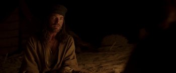 Movie still from “Last Days in the Desert” (2015), directed by Rodrigo García – A man with long hair sitting in the dirt; Medium shot, Over the shoulder angle