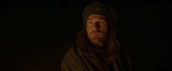 Movie still from “Last Days in the Desert” (2015), directed by Rodrigo García – A man with long brown hair and a turban; Close Up shot, Low angle