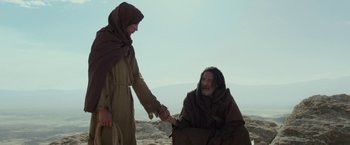 Movie still from “Last Days in the Desert” (2015), directed by Rodrigo García – A man and a woman holding each other's hands; Medium shot, Low angle