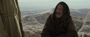 Movie still from “Last Days in the Desert” (2015), directed by Rodrigo García – An older man with a long beard sitting on top of a hill; Medium shot, Over the shoulder angle