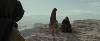 Movie still from “Last Days in the Desert” (2015), directed by Rodrigo García – A man and a woman are sitting on a hill; Wide shot, Low angle