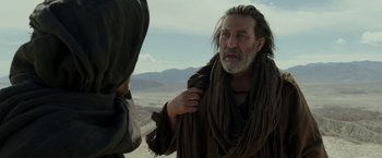 Movie still from “Last Days in the Desert” (2015), directed by Rodrigo García – An old man with a long grey beard is talking to a younger man; Medium shot, Over the shoulder angle