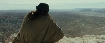 Movie still from “Last Days in the Desert” (2015), directed by Rodrigo García – A person sitting on top of a hill looking at a valley; Extreme Wide shot, Over the shoulder angle