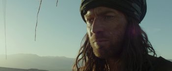 Movie still from “Last Days in the Desert” (2015), directed by Rodrigo García – A person with long dreadlocks; Close Up shot, Low angle