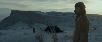 Movie still from “Last Days in the Desert” (2015), directed by Rodrigo García – A person standing in the snow next to a tent in the desert; Extreme Wide shot, High angle