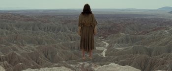 Movie still from “Last Days in the Desert” (2015), directed by Rodrigo García – A man standing on top of a mountain with his arms outstretched; Wide shot, Low angle