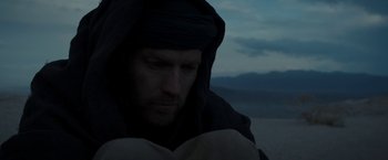 Movie still from “Last Days in the Desert” (2015), directed by Rodrigo García – A man with a beard and a black robe; Close Up shot, Low angle