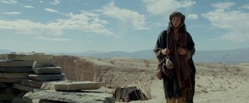 Movie still from “Last Days in the Desert” (2015), directed by Rodrigo García – A man standing on top of a dirt hill; Wide shot, Low angle