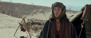 Movie still from “Last Days in the Desert” (2015), directed by Rodrigo García – A young man in the desert wearing a head covering; Medium shot, Low angle
