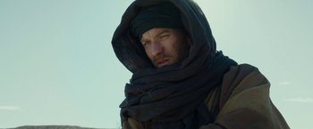 Movie still from “Last Days in the Desert” (2015), directed by Rodrigo García – A man with a beard wrapped up in a blanket; Close Up shot, Low angle