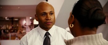 Movie still from “Last Holiday” (2006), directed by Wayne Wang – A man in a dress shirt and tie talking to a woman in front of a mirror; Close Up shot, Over the shoulder angle